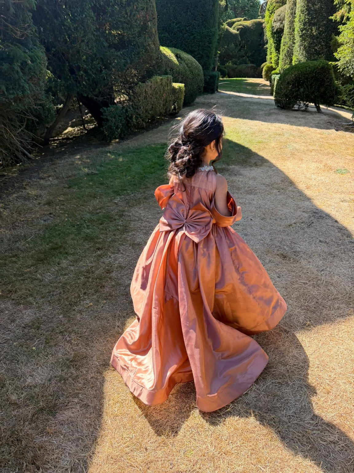 Rosalie gown in the garden, showing the back bow and flowing skirt