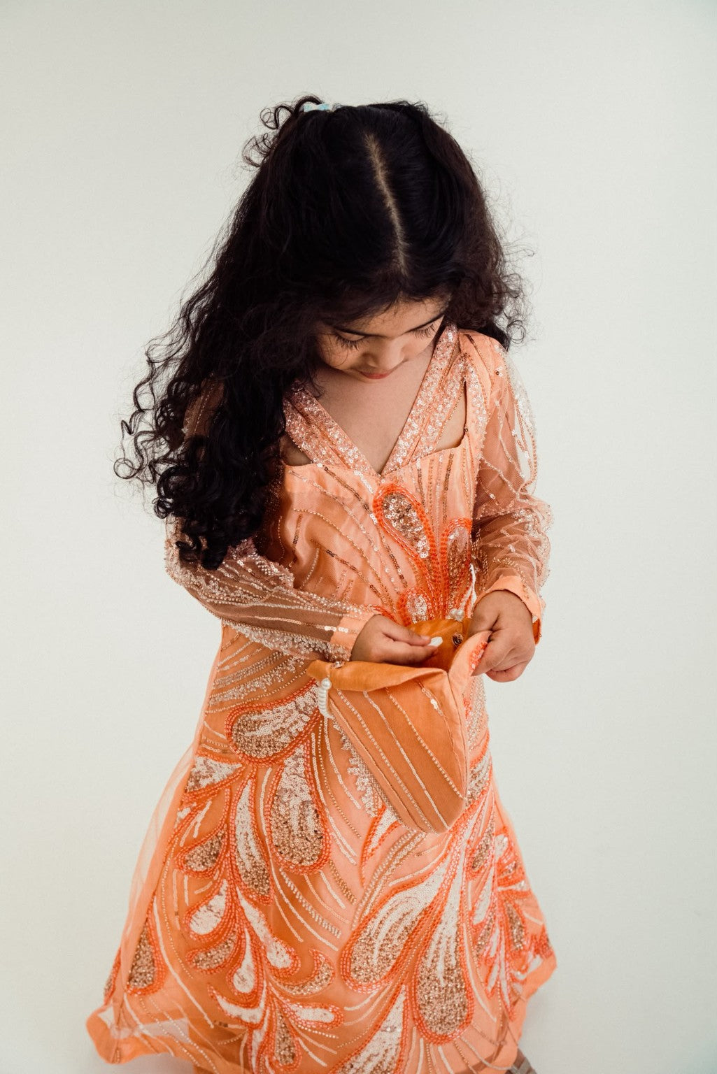 Zaria peach occasion dress with elegant V-neckline and sheer embellished sleeves